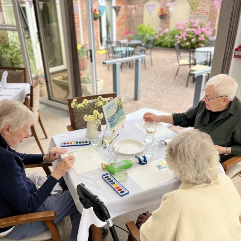 Salveo Care | 3 of our residents sat around a table getting involved in arts and crafts