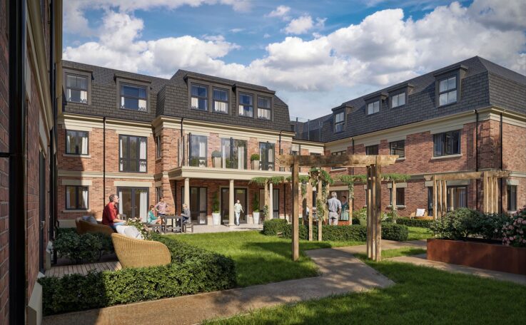 People are sitting and standing in a landscaped courtyard of a modern brick residential building with greenery and pathways under a blue sky with clouds.